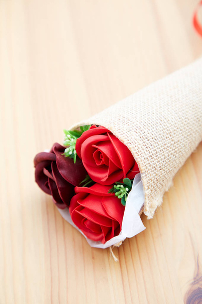 キッチンの木製のテーブルの上にバレンタインデーにカップルの贈り物のバラ、デザインのための空きスペース - 写真・画像