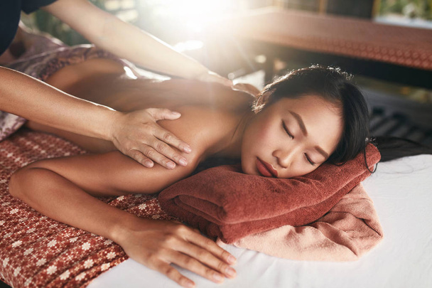 Rückenmassage im thailändischen Spa. Frau mit Körpermassage im Salon - Foto, Bild