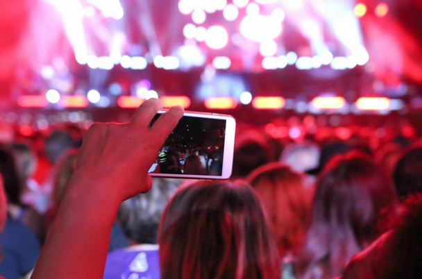 scattare foto al concerto dal vivo con smartphone e molte persone
 - Foto, immagini