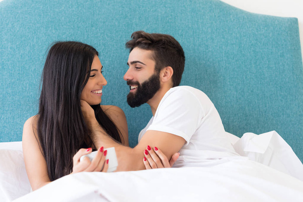 ベッドの中で美しい若い情熱的なカップル - 写真・画像