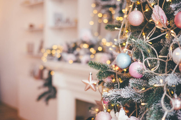 Foto parcialmente enfocada con árbol de Navidad decorado en frente y chimenea borrosa en la parte posterior
 - Foto, imagen