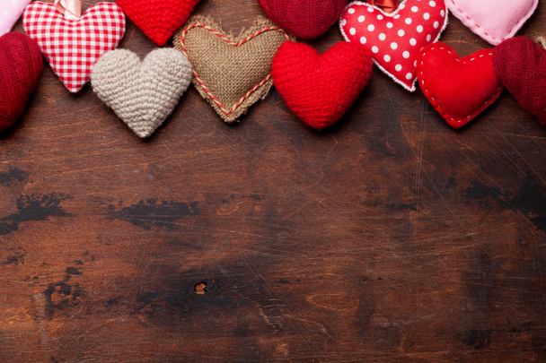 Dia dos Namorados cartão de saudação com brinquedos de coração artesanais no fundo de madeira. Vista superior com espaço para as suas saudações. Depósito plano
 - Foto, Imagem