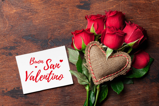 赤いバレンタインのグリーティング カードは花束の花を上昇し、木製の背景に心を編んだ。ヴァレンティノ イタリアをバウンドさせるサン。あなたの挨拶のためのスペースのトップ ビュー - 写真・画像