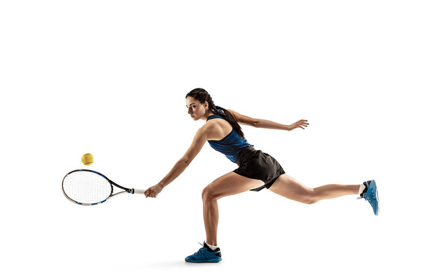 Full length portrait of young woman playing tennis isolated on white background - 写真・画像