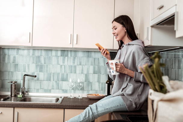 Happy woman having rest in the kitchen using social media - Foto, Bild