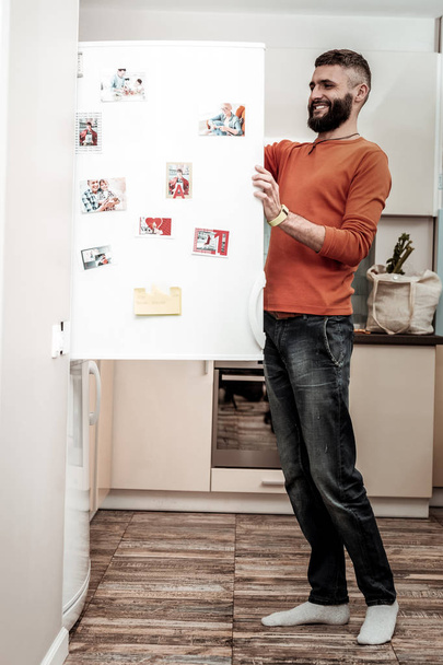 Cheerful husband feeling happy seeing his favorite dish in fridge - Photo, image