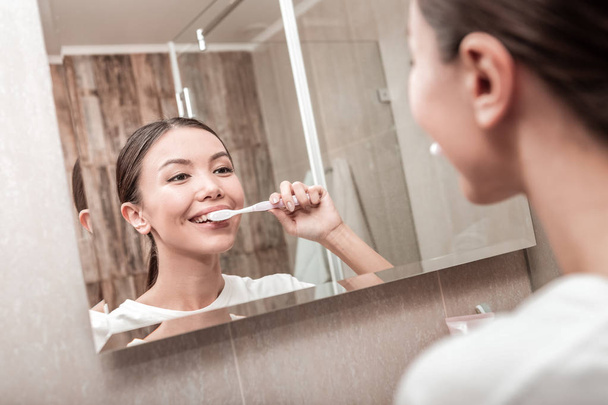 Young businesswoman brushing her teeth in the morning - Φωτογραφία, εικόνα
