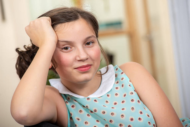 портрет красивой молодой девушки-подростка, сидящей на кресле
 - Фото, изображение