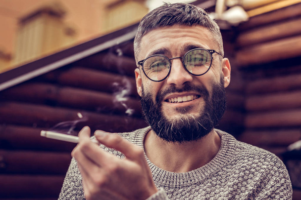 Joyful good looking man enjoying smoking cigarettes - Zdjęcie, obraz