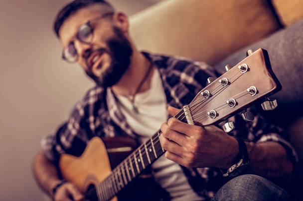 Selective focus of a guitar in male hands - Photo, image