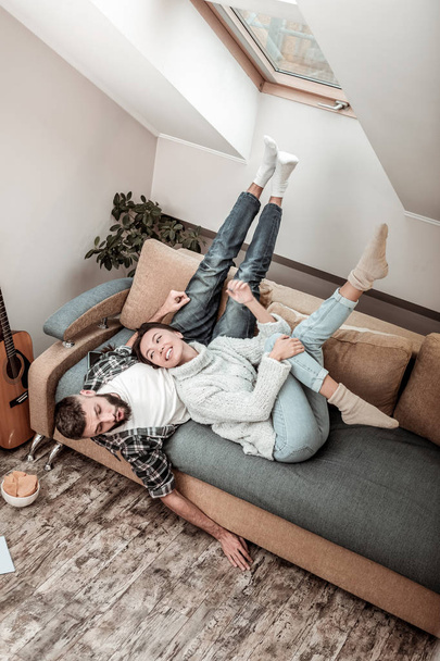 Cheerful nice couple resting on the sofa together - Фото, зображення
