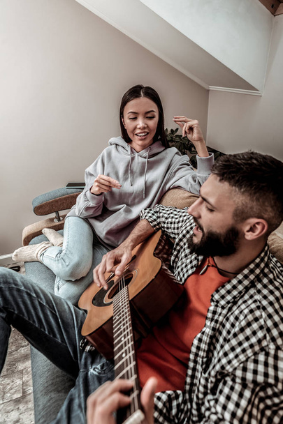 Pleasant young man playing a song for his girlfriend - Foto, Imagen