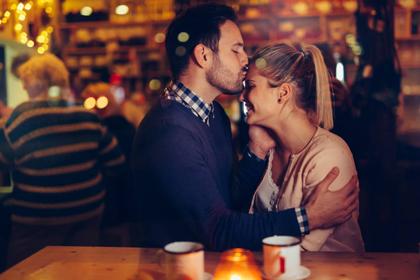 Romantic young couple dating in pub at night - 写真・画像