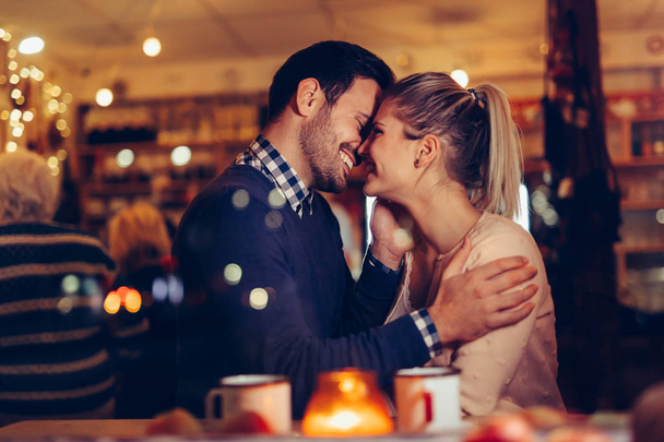 Romantic young couple dating in pub at night - Photo, image