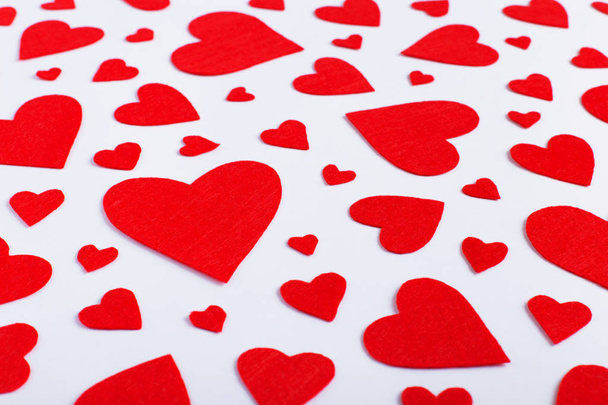 Red hearts of different sizes on white background. Harvesting cards for Valentine's Day. - Φωτογραφία, εικόνα