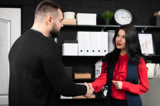 Business and office concept. Handshake of two businessmen in a modern office. Business people finish the deal. Businessman and woman shaking hands as Hello in office closeup - Foto, Bild