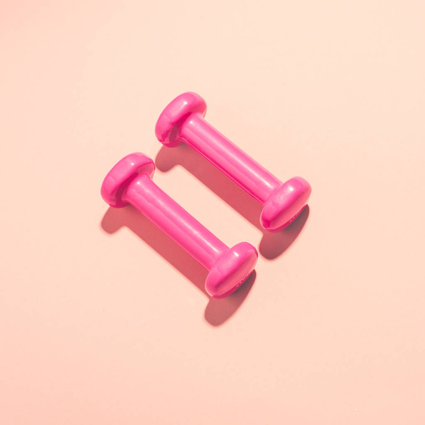 bright pink dumbbells on pink background - Photo, image