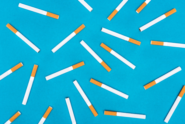 Puesta plana de cigarrillos aislados en azul
 - Foto, Imagen