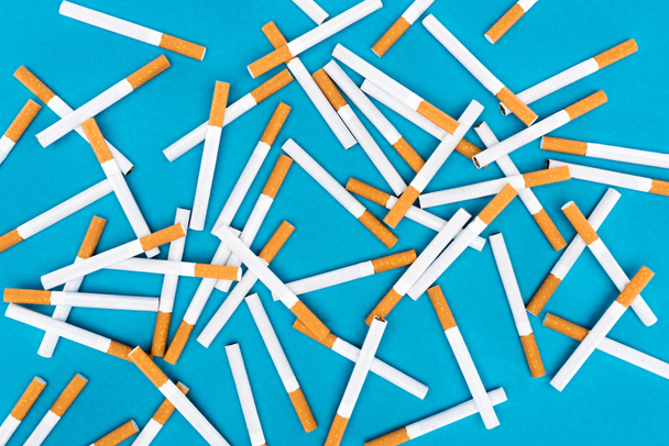 Vista superior de cigarrillos aislados en azul
  - Foto, Imagen