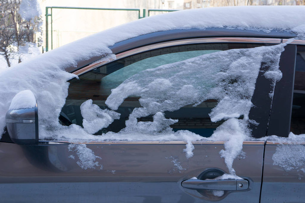 その車は、雪の厚い層で覆われています。大雪の否定的な結果。車の左の部分が雪で覆われて - 写真・画像
