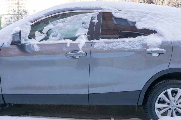 Az autó, vastag hó borítja. Havazás negatív következménye. az autó bal oldali részén a hóval - Fotó, kép