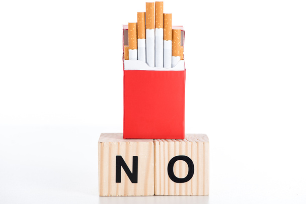 Estúdio tiro de maço de cigarro com cubos de madeira alfabeto isolado em branco, parar de fumar conceito
 - Foto, Imagem