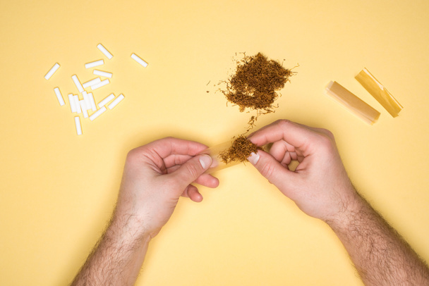 Частичное представление о молодом человеке, употребляющем табак изолированный на желтом
 - Фото, изображение