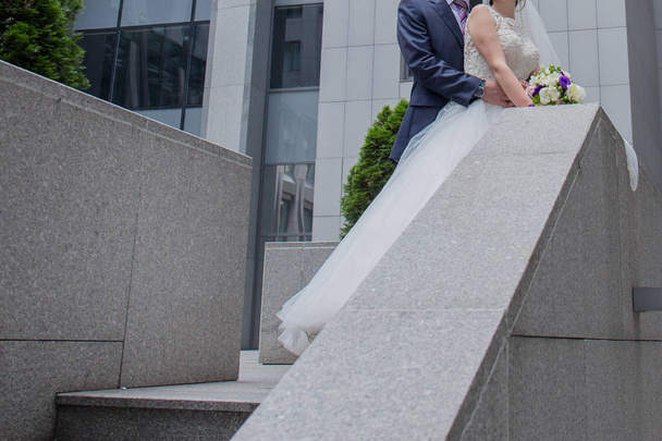 bride and groom are standing near the stairs - Foto, Imagen