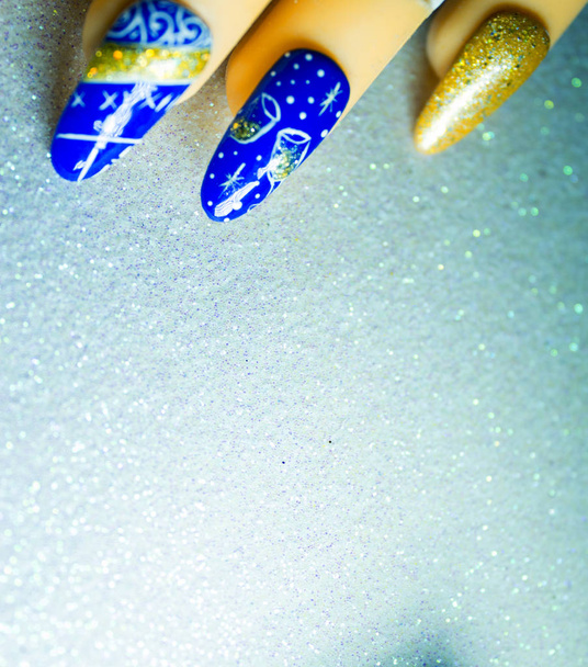 Permanente gel nagels met Nieuwjaar decoratie. Lichte achtergrond - Foto, afbeelding