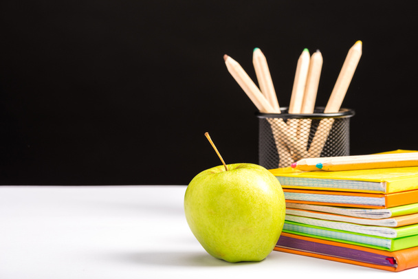 notebooks, pencils and apple isolated on black with copy space - Фото, изображение