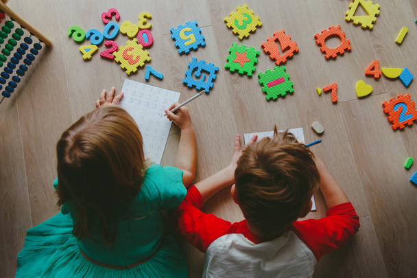 Kids - jongen en meisje-leren om te schrijven en het berekenen van de getallen - Foto, afbeelding