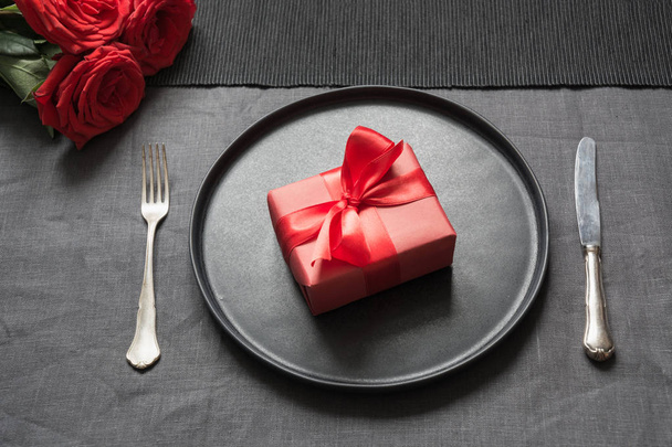 Valentine's day or birthday romantic dinner. Elegance table setting with red rose on black linen tablecloth. - Fotografie, Obrázek