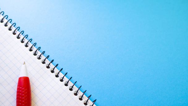 Блокнот для записей с ручкой на синем фоне. Вид сверху с пространством для копирования
 - Фото, изображение