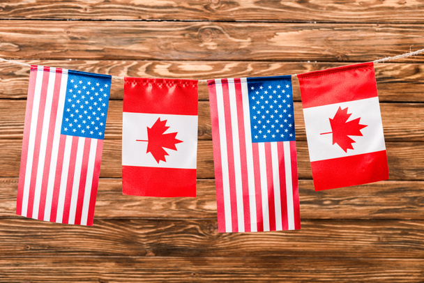 top view of canadian and american flags on wooden background - Photo, Image