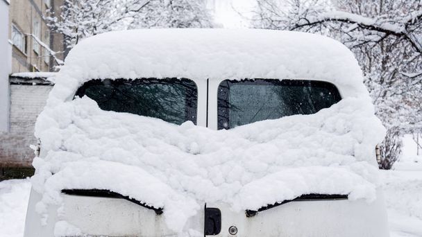 Снег на машинах после снегопада. Зимняя городская жизнь. заднее стекло, как глаза
 - Фото, изображение