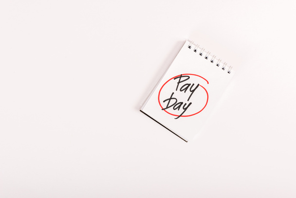 top view of notebook with 'pay day' lettering isolated on white - Photo, Image