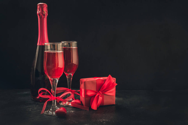Valentine's day and birthday greeting card with red champagne and heart candy on black. Space for text and greetings. - Fotografie, Obrázek