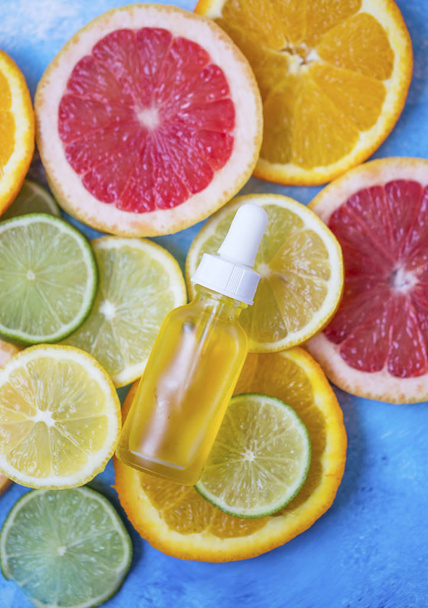 Zitrusölflasche mit Limetten-, Orangen-, Zitronen- und Grepfruchtscheiben, pflanzliches Pflanzenöl aus Zitrusfrüchten - Foto, Bild