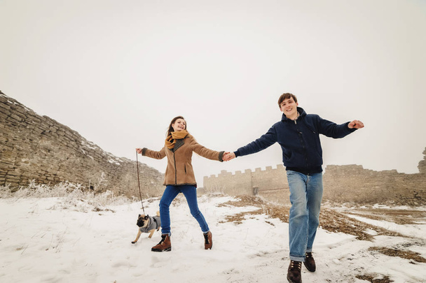 Casal encantador andando em ruínas do castelo velho no dia de inverno nevado
 - Foto, Imagem