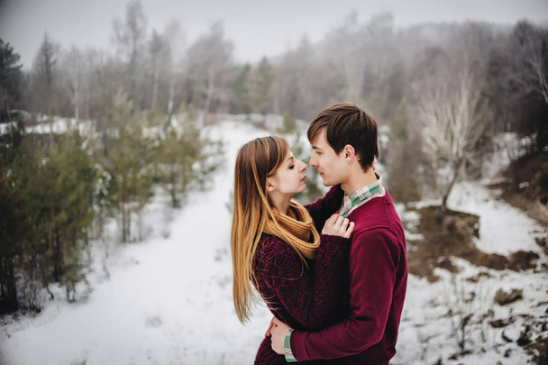 Portrait of young happy couple in snowy winter landscape  - Photo, image