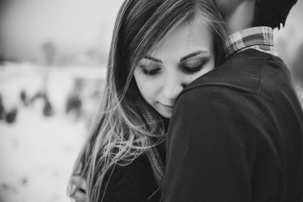 Happy couple hugging in snowy winter park - Фото, зображення