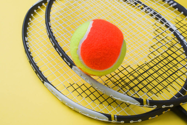Tennis Ball and rackets on yellow Background, Sport Concept and Idea - Foto, afbeelding