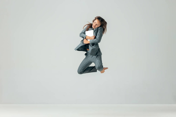 Happy business woman dancing and smiling isolated over white. - 写真・画像