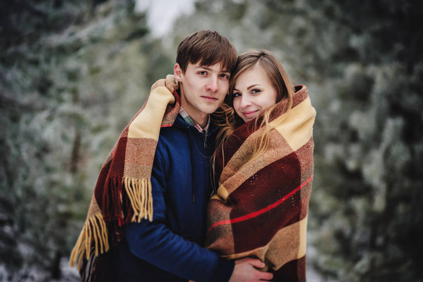 Portrait of young happy couple in snowy winter landscape  - Photo, Image