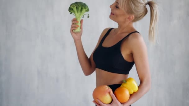 Mujer delgada feliz sosteniendo frutas y verduras frescas
 - Imágenes, Vídeo