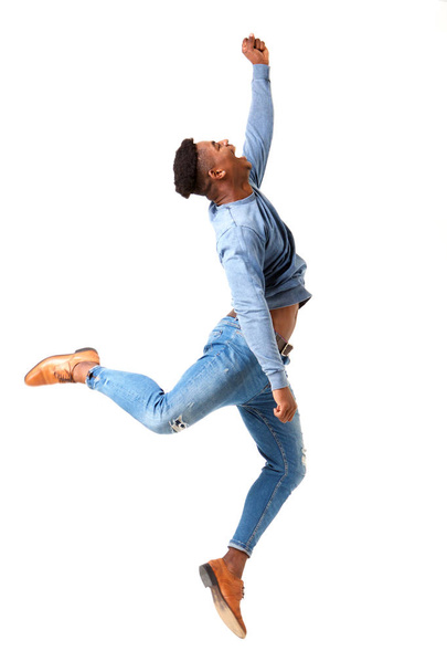 Profilo completo del corpo ritratto di felice giovane uomo nero che salta per la gioia contro isolato sfondo bianco
 - Foto, immagini