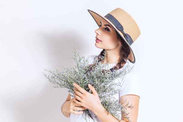 Happy positive young woman with bouquet of wild flowers over white background - Photo, image