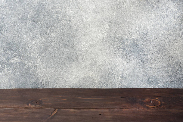 Mesa de madera con fondo de pared de hormigón, para su montaje fotográfico o visualización de productos, espacio para colocar artículos en la mesa
. - Foto, imagen