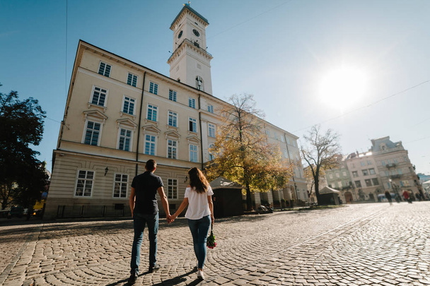 Young happy man and woman walking along streets of city - Valokuva, kuva