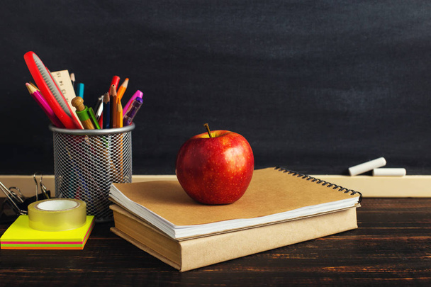 Yazma malzemeleri, bir kitap ve bir elma, metin için boş veya bir okul teması için bir arka plan ile Öğretmen masası. Kopyalama alanı. - Fotoğraf, Görsel